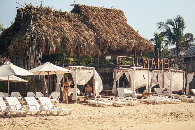Playa Blanca Barú: VIP Access to Mambo Beach Club - Clear water, rocks, boats, and a public beach